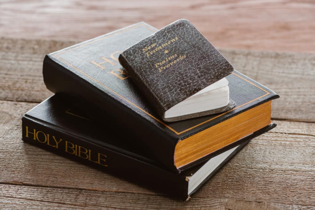 Various types of Bibles laying on wooden desk for ministries and churches