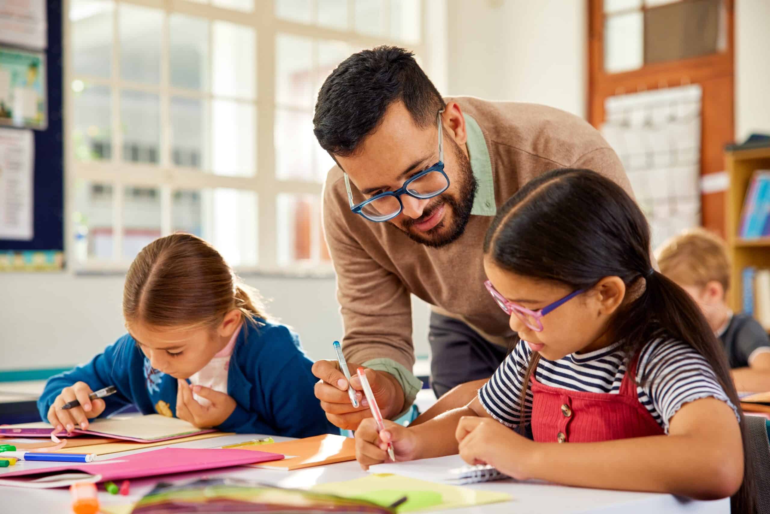 Male teacher reviewing student's work in an educational institution