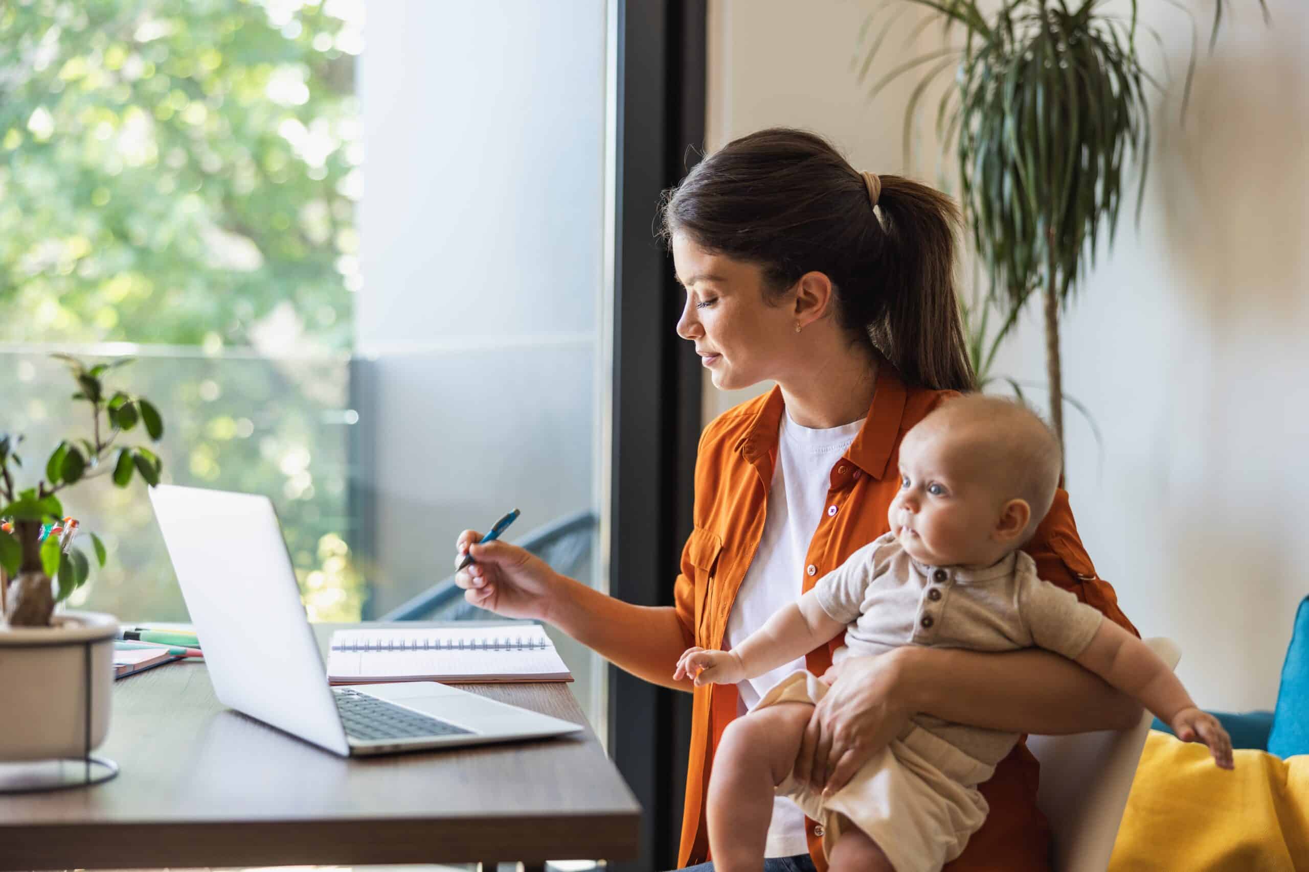 Mommy influencer with her baby writing in her journal