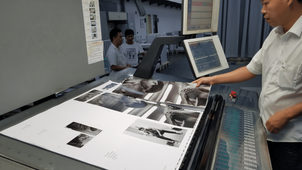 Man reviewing education prints in an overseas factory in Asia