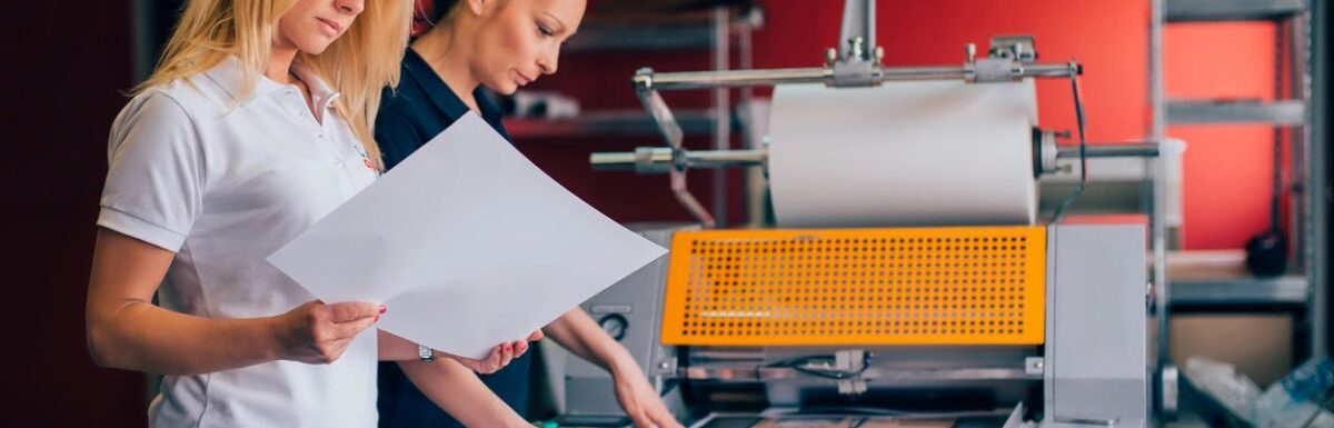 Two women reviewing physical print samples for overseas printing