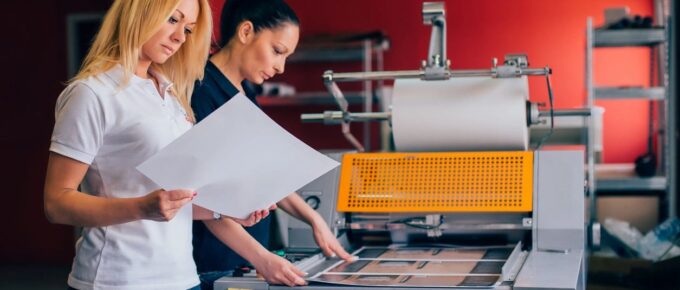 Two women reviewing physical print samples for overseas printing