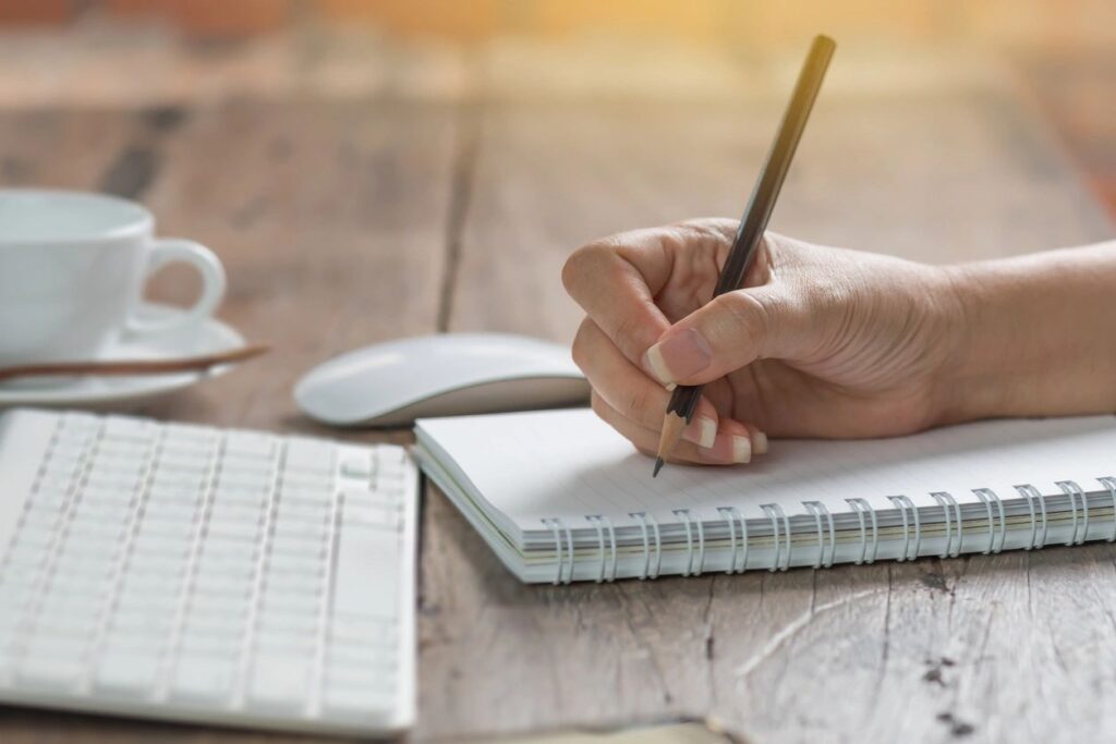 Female author writing in her spiral journal