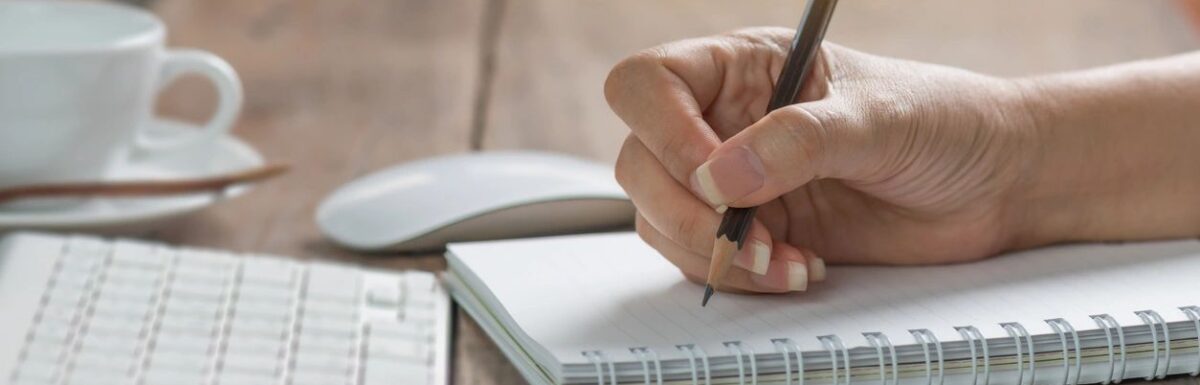 Female author writing in her spiral journal