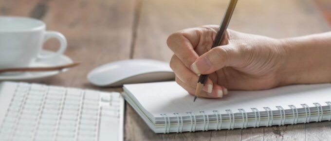 Female author writing in her spiral journal