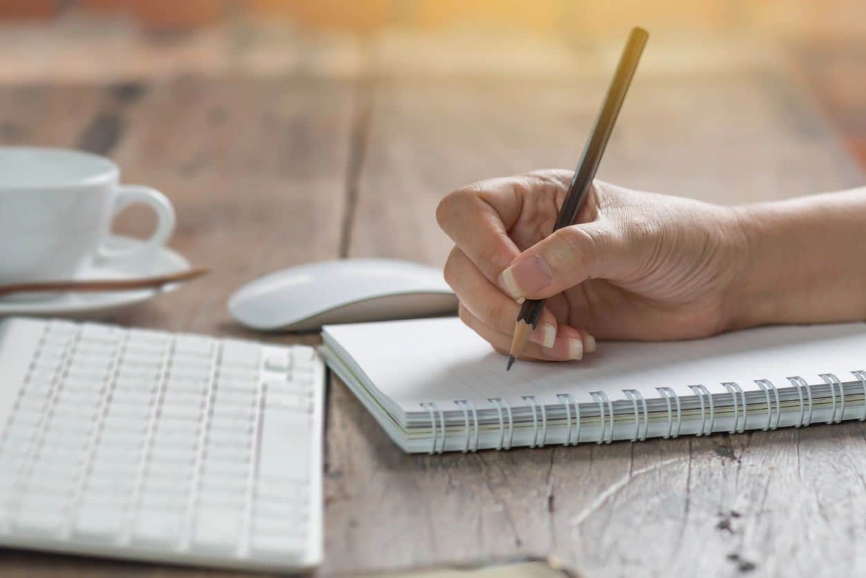 Female author writing in her spiral journal