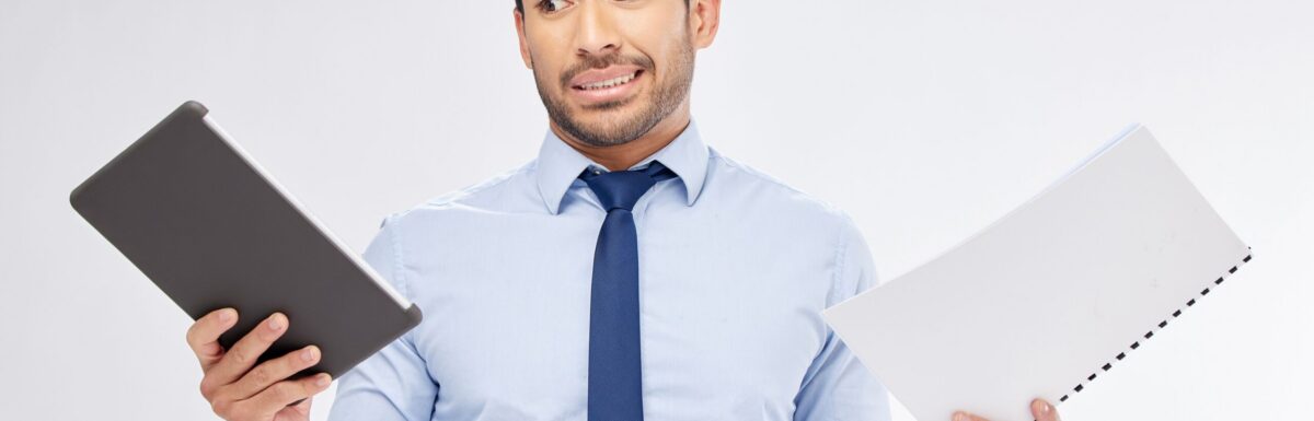 Man holding an ipad (digital) and a hardcopy booklet (print)