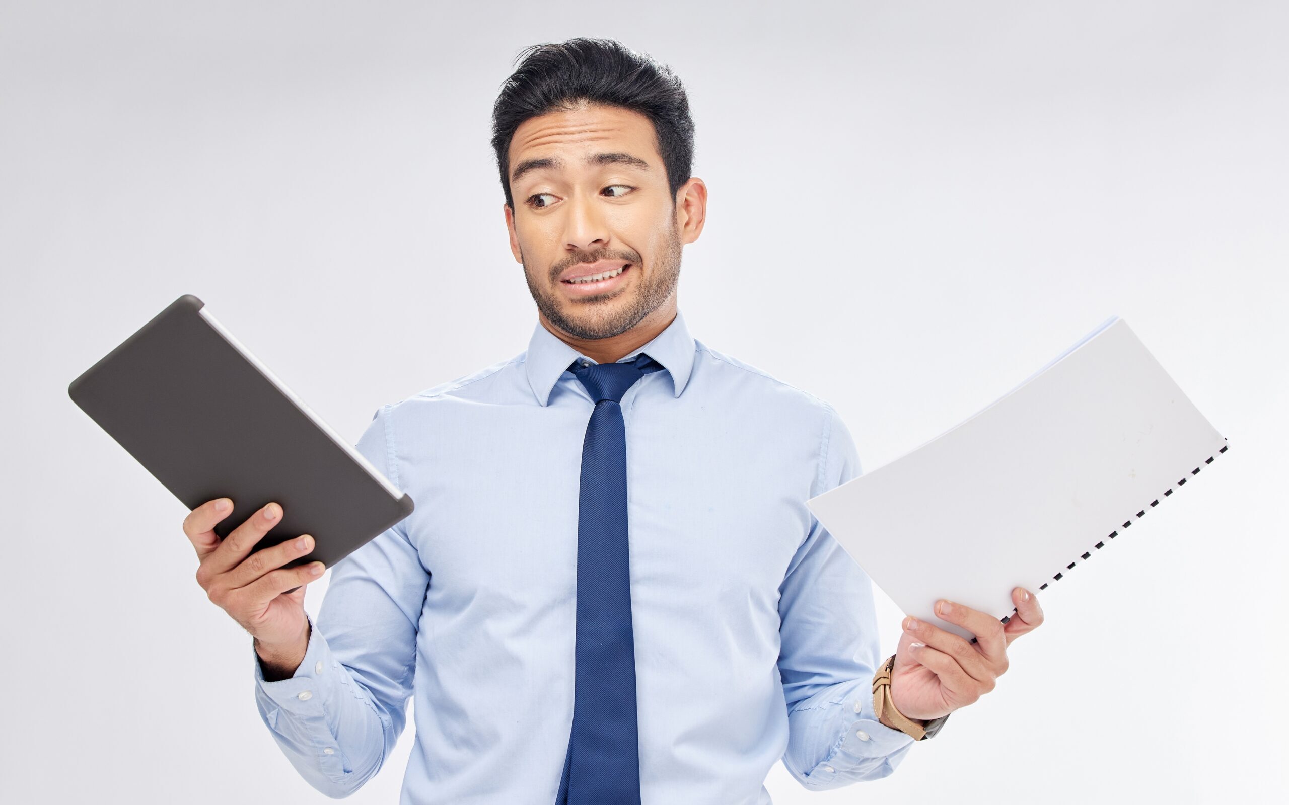 Man holding an ipad (digital) and a hardcopy booklet (print)