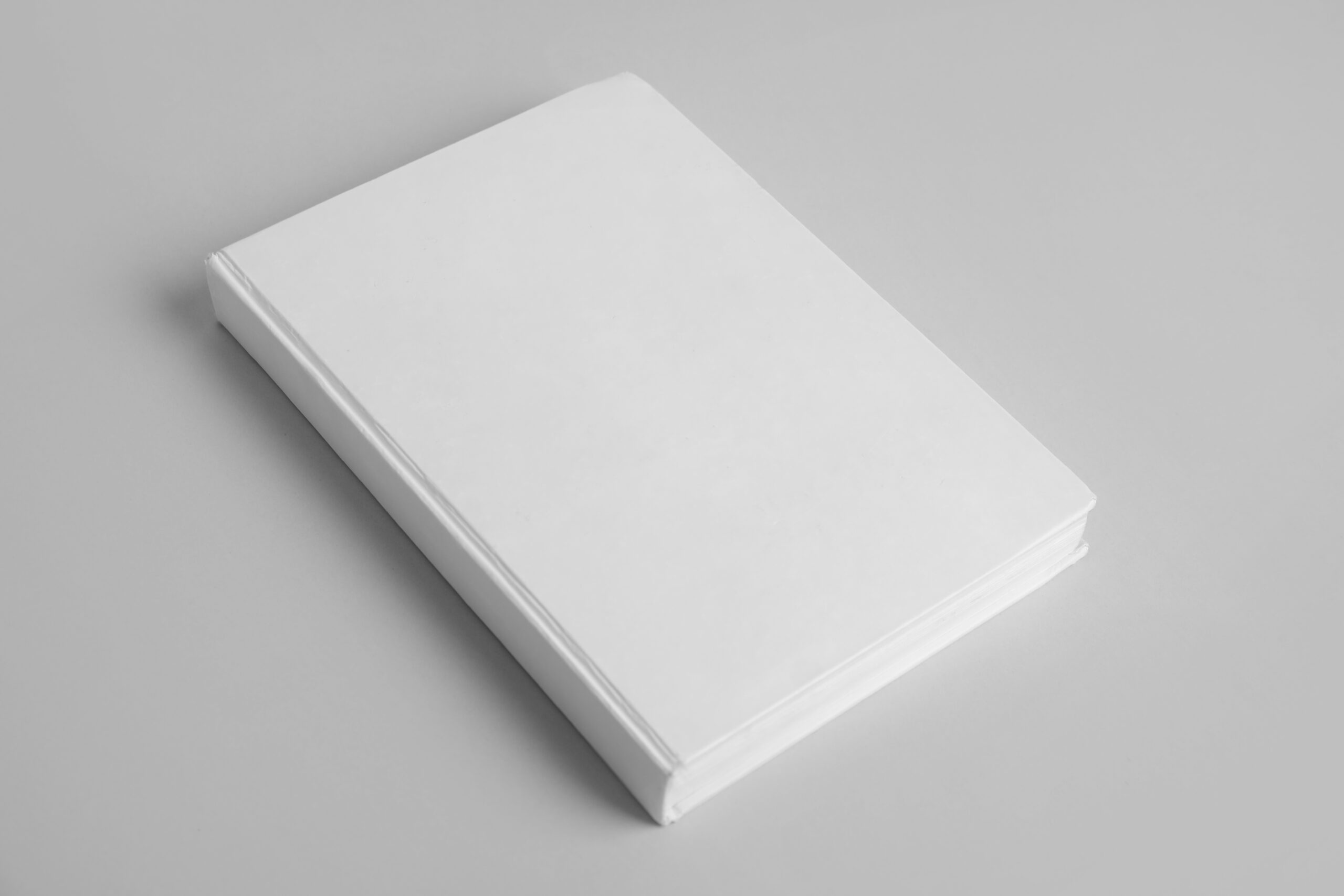 Blank white book laying on table. Overseas white dummy sample for clients.