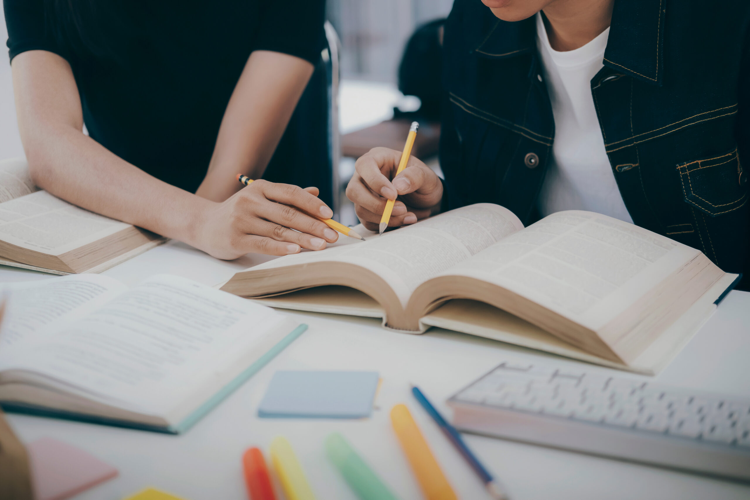 University students studying and pointing in a textbook.
