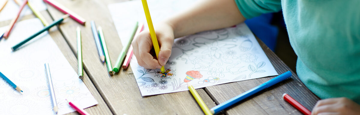 Children Coloring with markers on coloring page