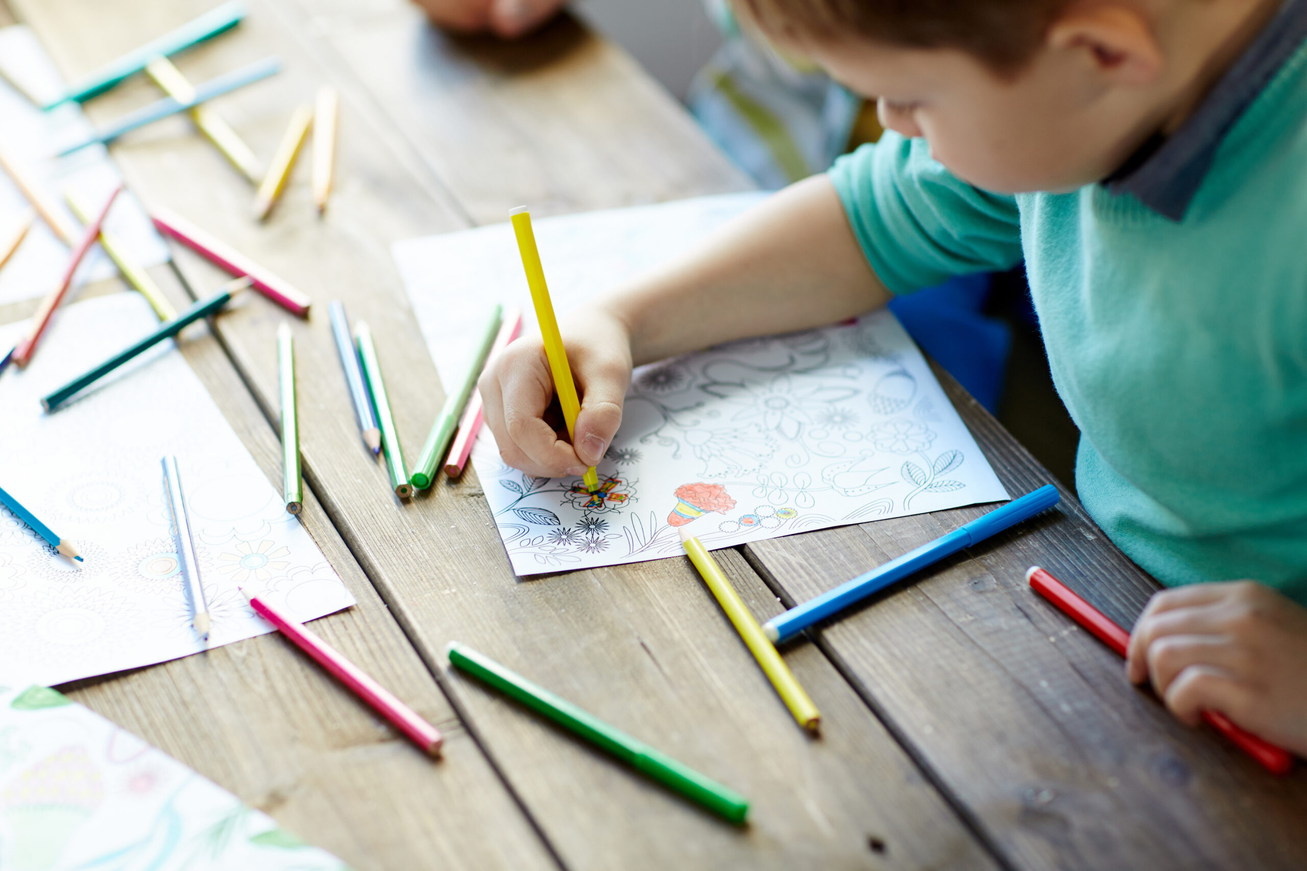Children Coloring with markers on coloring page