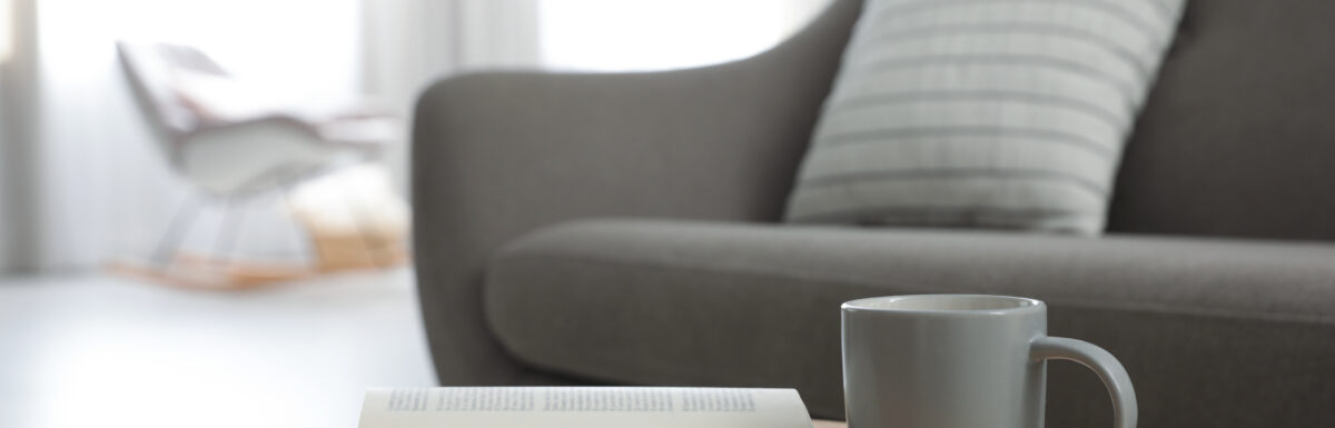 Living room setting with a coffee table book and mug.