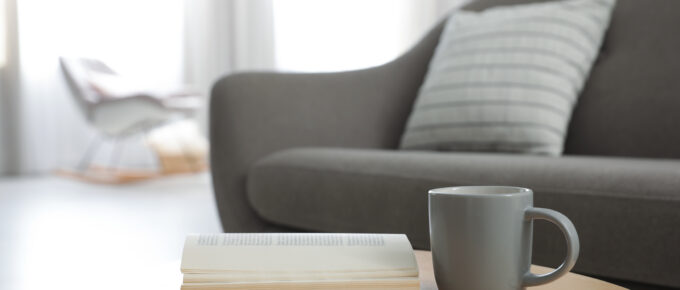 Living room setting with a coffee table book and mug.