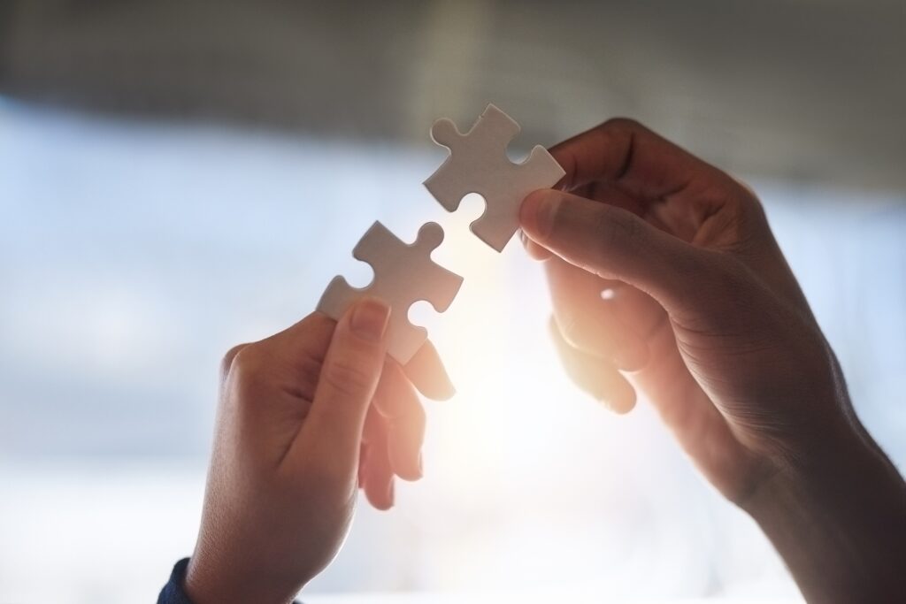 Two hands holding puzzle pieces, collaboration