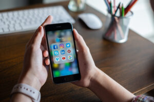 Women holding phone with social media applications